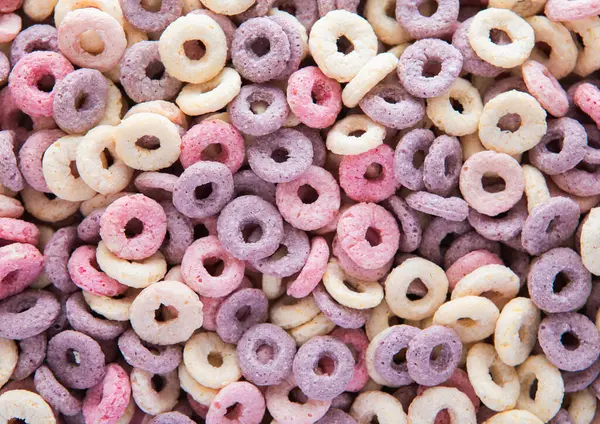 Meyve çemberli mısır gevreği. Arka planda yabanmersini, muz ve çilek aromalı..