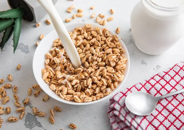 Ballı süt dökmek için içine pirinç gevreği sabah kahvaltısı kaşık ve mutfak havlusu..