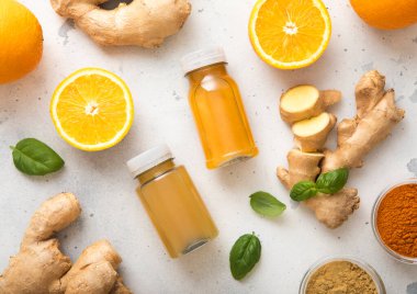 Bağışıklık sistemi zencefil ve turuncu enerji içecekleri. Hafif arkaplanda zencefil kökü ve zerdeçal tozu var..