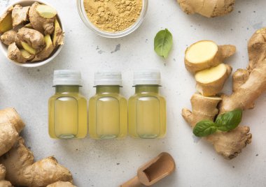 Bağışıklık sistemi kızıl enerjili içecek şişeleri taze zencefil kökü ve hafif arka planda toz..