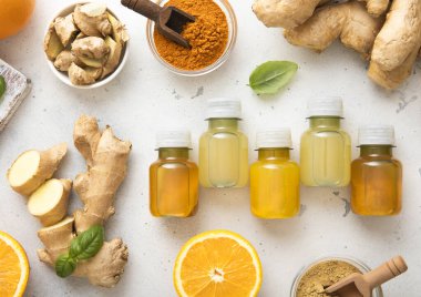 Bağışıklık sistemli zencefilli enerji içeceği taze zencefil kökleri ve açık arkaplanda portakallı meyve..