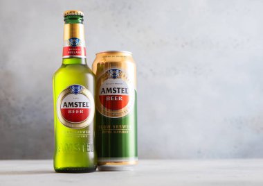 LONDON, UK - 15 Temmuz 2025: Hafif arkaplanda bira demlenmiş Amstel Dutch şişesi ve teneke kutu.