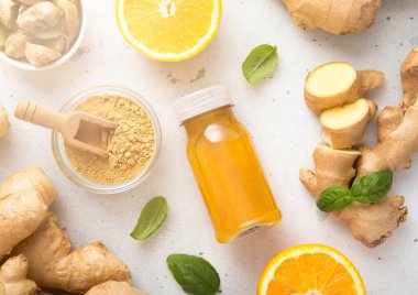 Zencefil ve turuncu enerji içeceği. Mutfak arka planında zencefil kökü ve topraklanmış toz..