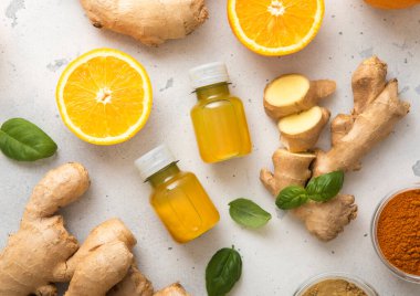 Taze zencefil kökü ve hafif arka planda portakallı bağışıklık sistemi enerji içeceği..