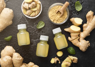 Zencefil kökü ve siyah zemin üzerine topraklanmış toz içeren bağışıklık güçlendirici enerji içeceği..