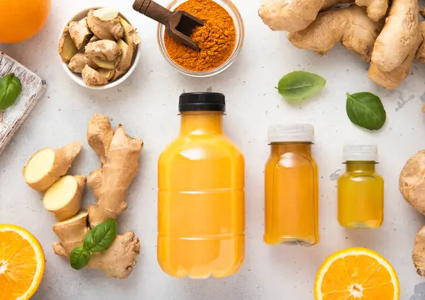 Zencefil ve turuncu enerji aşısı. Mutfak arka planında zencefil kökü ve zerdeçal tozu olan bağışıklık ilacı..