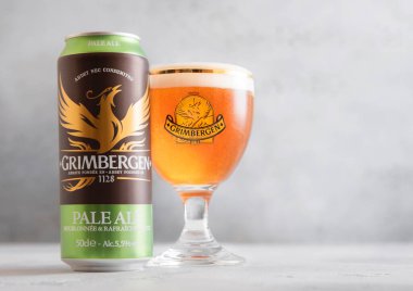 LONDON,UK - APRIL 10,2025: Grimbergen pale ale beer in original glass and aluminum can on light table.