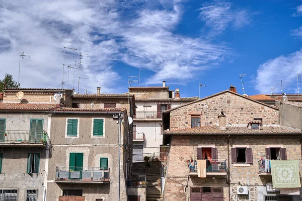Roofs with antennas and walls with windows and balconies in a small town in Tuscany, Italy