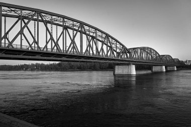 The Vistula River and the steel structure of the road bridge in the city of Torun, Poland, monochrome