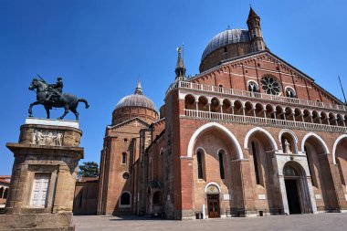 Statue of a mounted knight and the facade of the medieval church of St. Anthony in the city of Padua, Italy