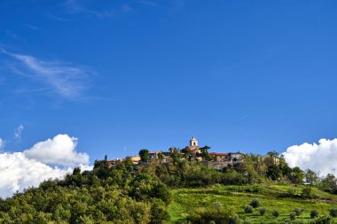 tower of a stone medieval church in the village of Montiano in Tuscany, Italy