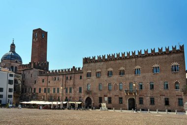 Historic buildings, tables and umbrellas of a restaurant in Piazza Sordello in the city of Mantua, Italy