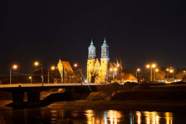 Warta nehri üzerindeki köprü ve geceleyin Polonya Poznan 'daki gotik katedral.