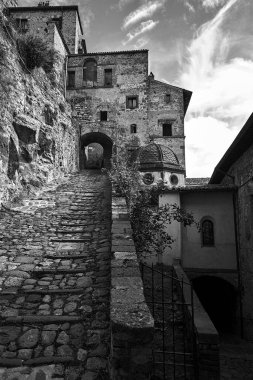 Taş basamaklı bir sokak ve Bolsena, İtalya 'da tek renkli bir kapı.