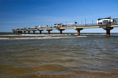 Polonya 'nın Miezyzdroje kentinde Baltık Denizi kıyısında beton bir iskelede turistler