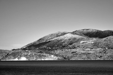 Yunanistan 'ın Kefalonya adasındaki İyon Denizi üzerindeki bir tepede rüzgar türbinleri, monokrom