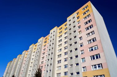 Polska 'nın Poznan şehrinde balkonları ve pencereleri olan çok katlı modern bir binanın ön cephesi