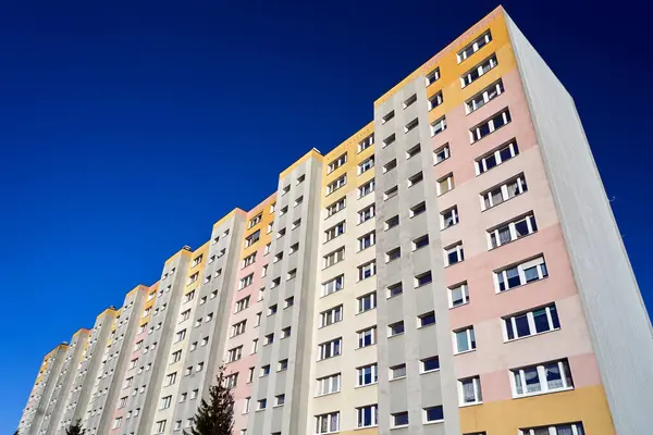 Polska 'nın Poznan şehrinde balkonları ve pencereleri olan çok katlı modern bir binanın ön cephesi