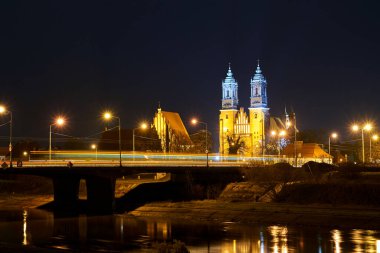 Warta nehri üzerindeki köprü ve gece Poznan, Polonya 'daki gotik katedral.