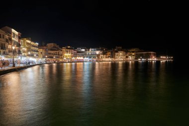 Yunanistan 'ın Chania kentindeki limanda gece vakti turistler, meyhaneler ve evler