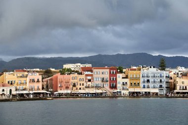 Yunanistan 'ın Girit adasındaki Hanya limanında meyhaneler, tarihi binalar ve turist kalabalığı