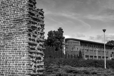 Polonya 'nın Poznan şehrinde bir ortaçağ savunma duvarı ve modern bir tuğla bina.