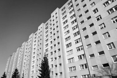 Poznany şehrinde balkonları ve pencereleri olan çok katlı modern bir binanın ön cephesi.