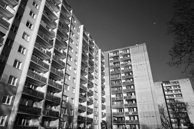 Polonya 'nın Poznan şehrinde balkonları ve pencereleri olan çok katlı modern bir binanın ön cephesi.