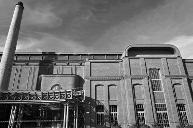Polonya 'nın Poznan kentindeki yenilenmiş eski bira fabrikası ve bacası tek renkli.