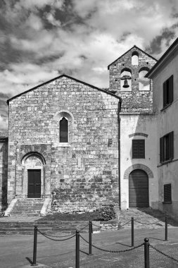 İtalya 'nın Toscana kentindeki Magliano kasabasında çan kulesi olan bir ortaçağ kilisesinin taş cephesi.