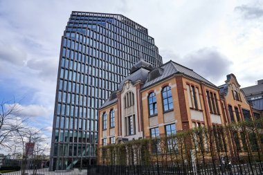 Eski bir matbaanın tarihi binası ve Poznan, Polonya 'da modern bir ofis binasının cephesi.