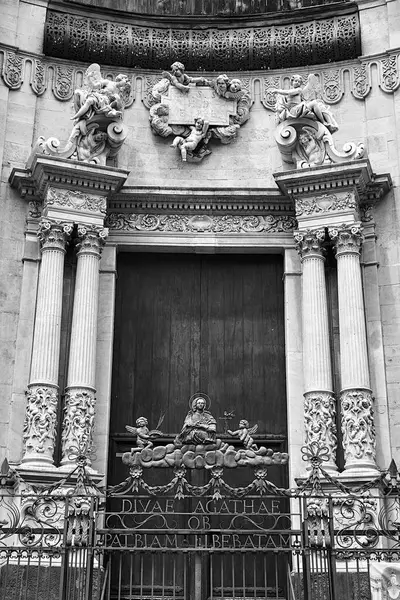 stock image Columns and statues of the Baroque portal of the Cathedral Basilica of St. Agates in the city of Catania, on the island of Sicily, Italy,  monochrome