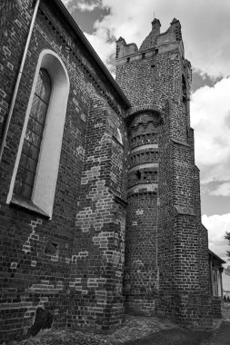 The brick, historic, gothic parish church of St. Nativity of the Blessed Virgin Mary in the village of Kamionna, Poland,  monochrome