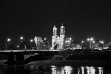 Warta nehri üzerindeki köprü ve gece Poznan, Polonya 'daki gotik katedral, tek renk.