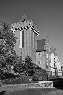 Metal giriş kapısı ve kule kırmızı tuğla yeniden inşa edilmiş kraliyet kalesi Poznan, Polonya, monokrom