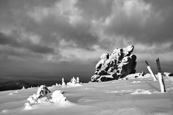 Одинокая скала и заснеженная туристическая тропа в Гигантских горах, Польша, монохром