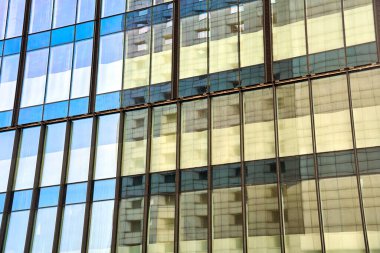 Gökyüzünün yansıması ve komşu bina Polonya 'nın duvarına sahip modern bir binanın cam cephesi.