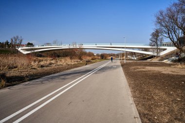 Polonya Poznan 'da asfalt yaya ve bisiklet yolu üzerinde modern yaya köprüsü