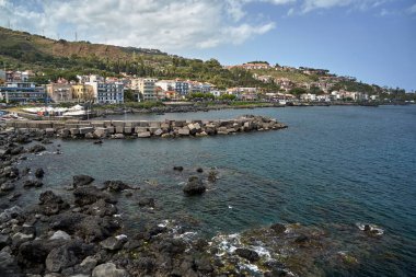 İtalya 'nın Sicilya adasındaki Aci Castello kasabasının taş ve beton dalgalı körfezi.