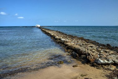 Yunanistan 'ın Girit adasındaki Georgioupoli kasabasında taştan bir burunda beyaz bir Ortodoks şapeli.