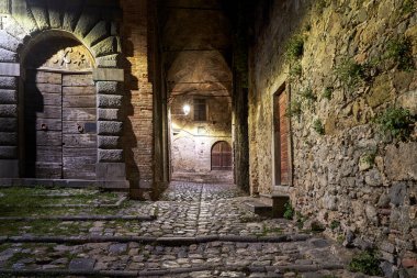 İtalya, Bolsena 'da gece taş binalar ve ahşap kapılı kaldırımlar
