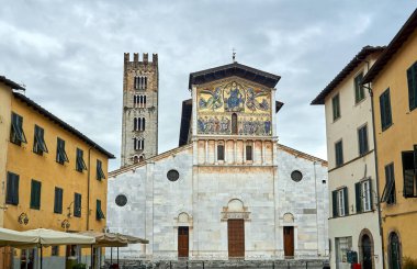İtalya 'nın Lucca kentindeki tarihi kilise ve çan kulesinin taş cephesi.