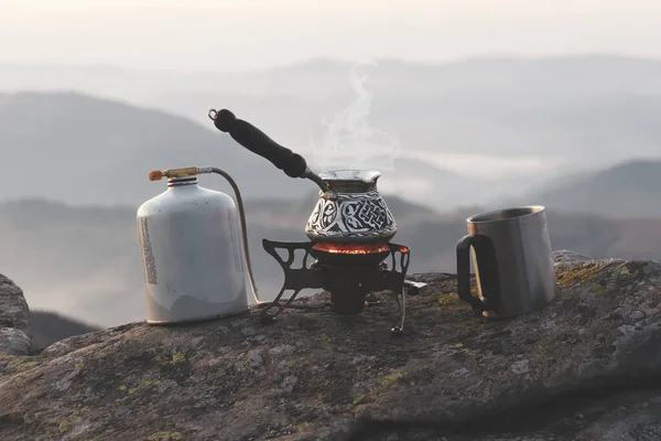 Hot morning drink in the wild. Preparing coffee on the gas camping stove. Camping coffee kit
