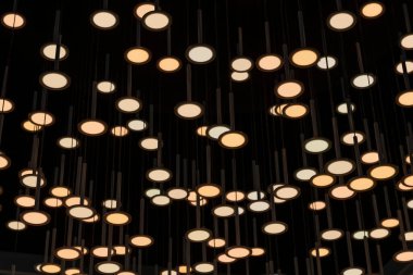 Celling with multiple round lanterns  of white color. Selective focus