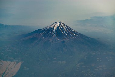 Mount Fuji silhouette, view from the plane. Snow crater of Fuji volcano.
