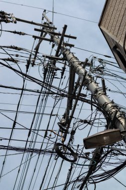 Chaotic web of electric wires in Fukuoka city, Japan. Asian mess of electric cables 