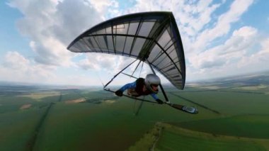 Kız planör pilotu diğer pilotlarla birlikte havada uçuyor.