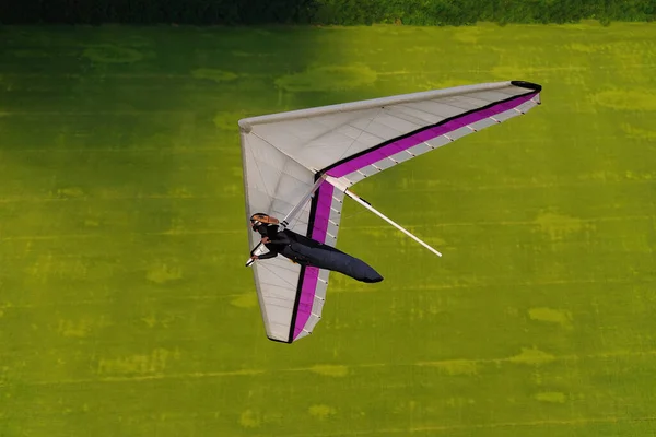 悬挂滑翔机飞行员在空中与他的机翼玩耍 悬挂式滑翔特技飞行的航拍 — 图库照片