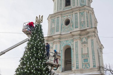 2023-12-05 Kyiv, Ukrayna. Belediye çalışanları Kyiv 'de Noel ağacını kurarken, arka planda Aziz Sophia çan kulesi bulunuyor.