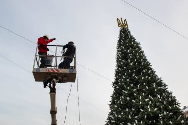 2023-12-05 Kyiv, Ukrayna. Belediye çalışanları Noel ağacını süslemek için araba kulesine çıkıyorlar.